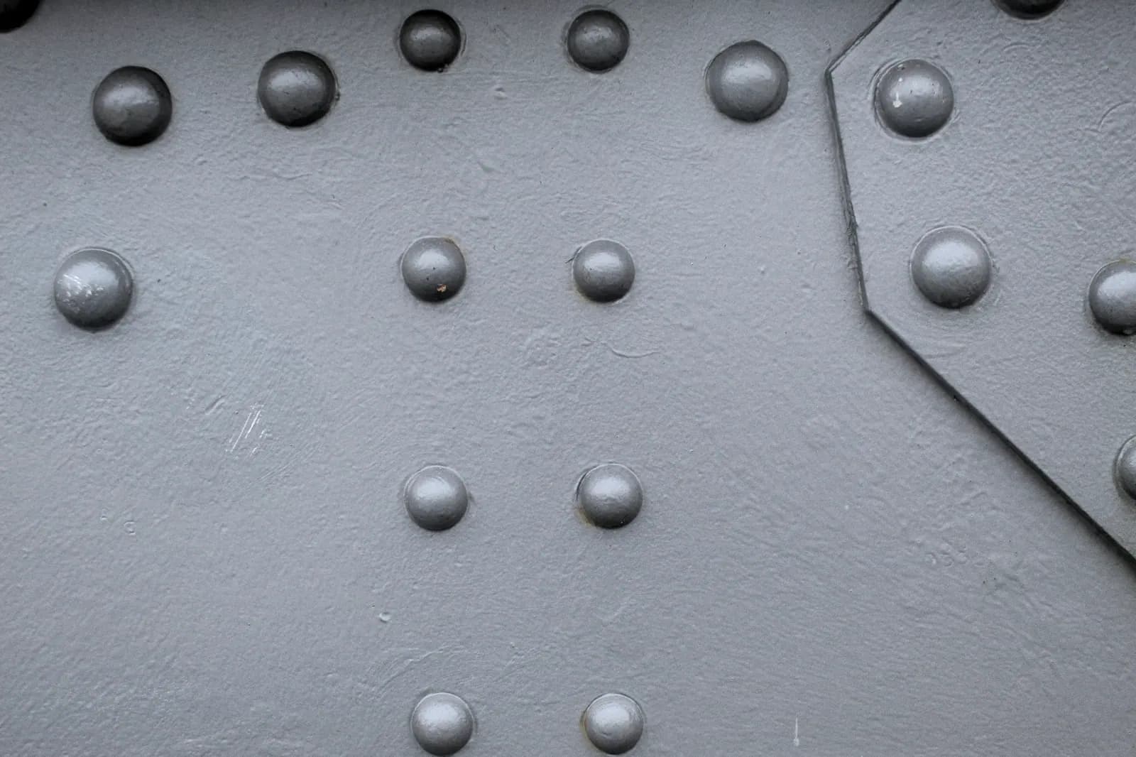 Platine d'acier rivetée en gros plan, têtes de rivets alignées