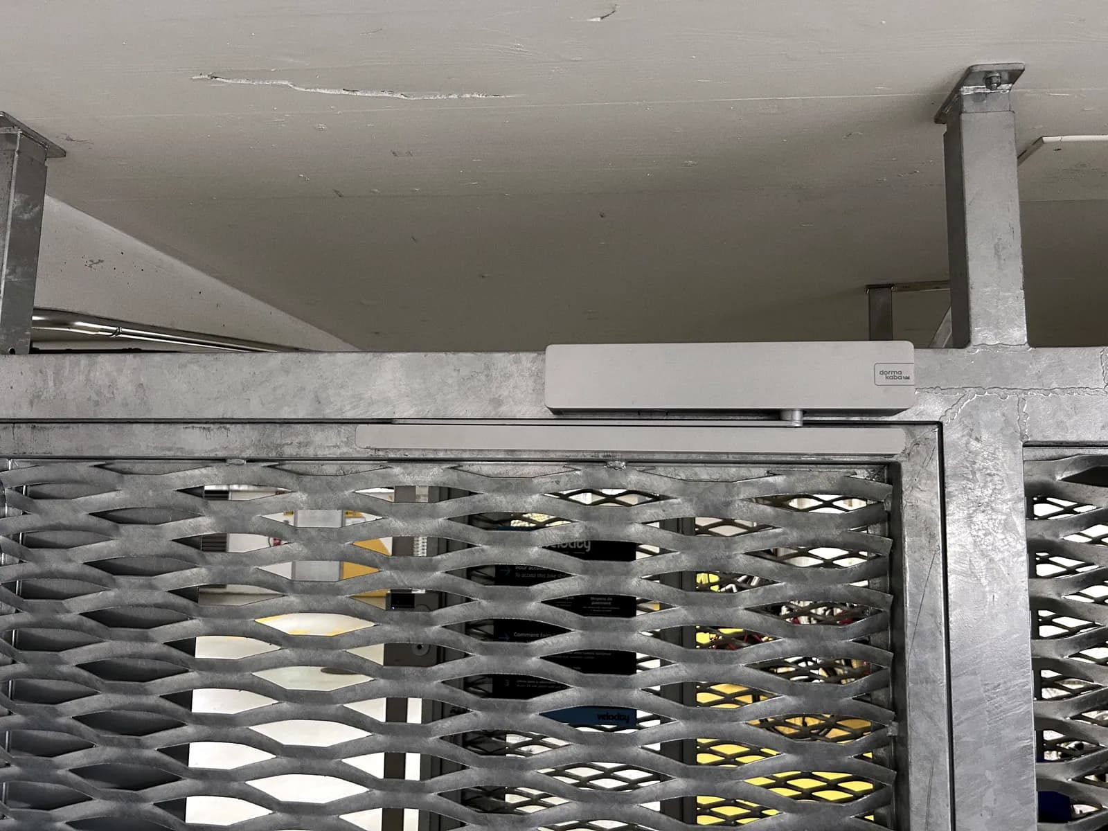 Panneau de métal déployé dans son cadre en acier, ferme-porte en partie haute